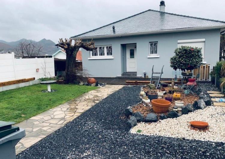 un cortile con una casa e un giardino con un sentiero roccioso di Cosy Maison LOURDES a Lourdes