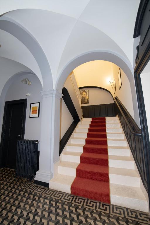- un escalier dans un bâtiment doté d'un tapis rouge dans l'établissement La Maison VH, à Mont-de-Marsan