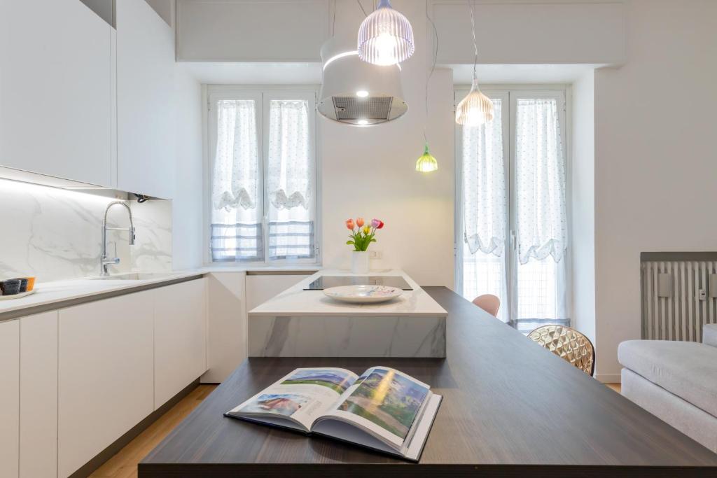 a kitchen with a table with a book on it at Design Premium Apartment in Center Milan - HomeUnity in Milan