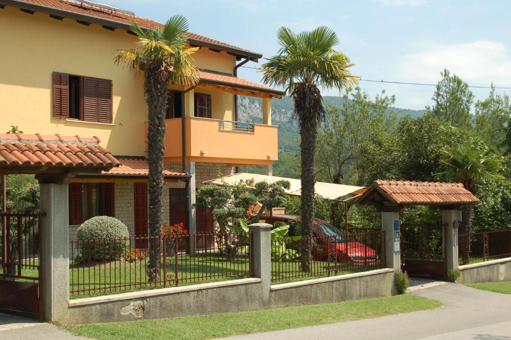 a house with palm trees in front of it at Apartment Pino in Roč