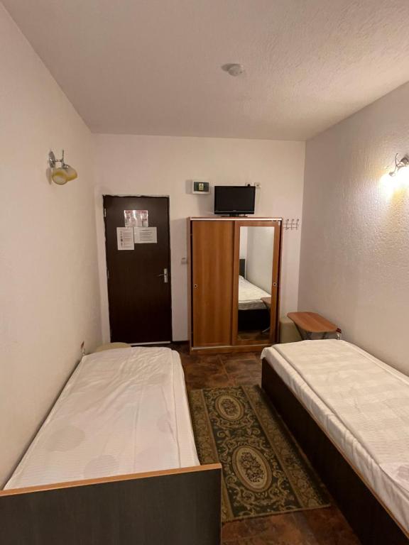 a small room with two beds and a mirror at PO LARI AMP in Ploieşti