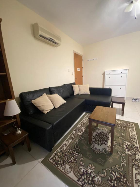 a living room with a black couch and a table at Paralimni in Paralimni