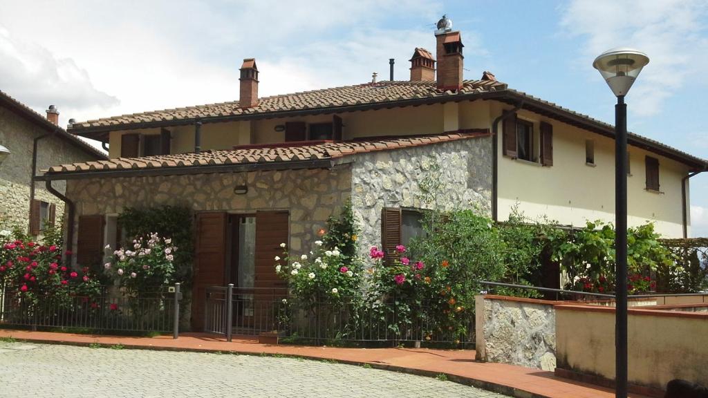une maison avec une porte et des fleurs devant elle dans l'établissement Vicino circuito Mugello, Panoramico con piscina, à Bovecchio