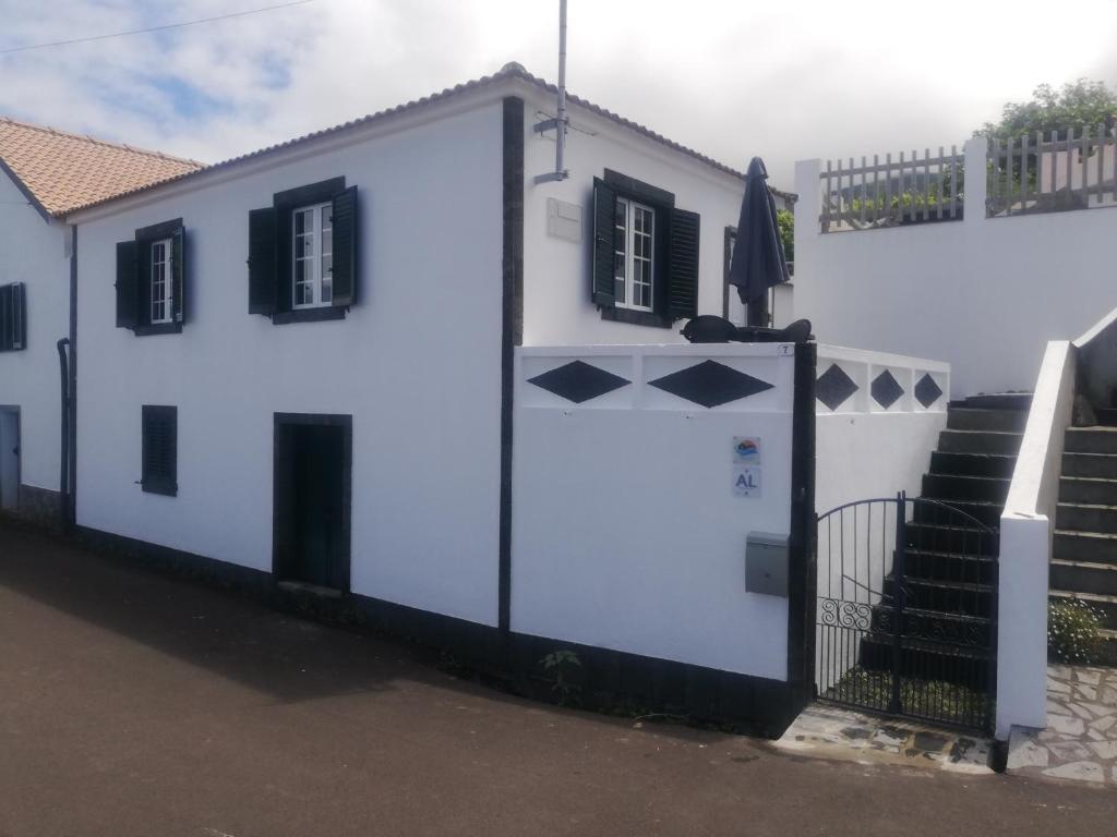 a white building with a gate and some stairs at Vitamin Sea in São Roque do Pico