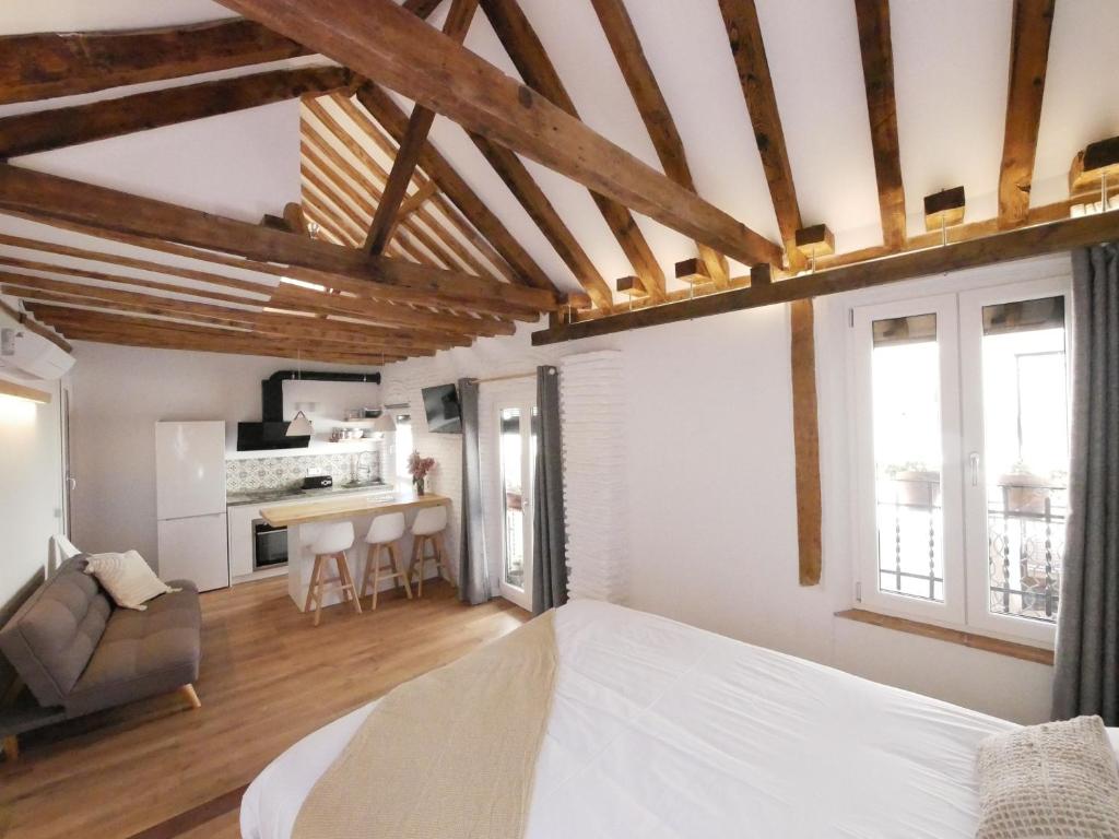een slaapkamer met een wit bed en een keuken bij Baños del Agua in Granada