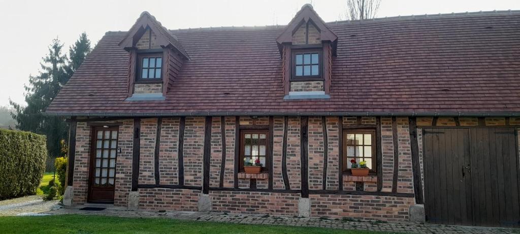 Saint-HellierLe petit gîte de la Varenne的砖屋,带窗户和棕色屋顶