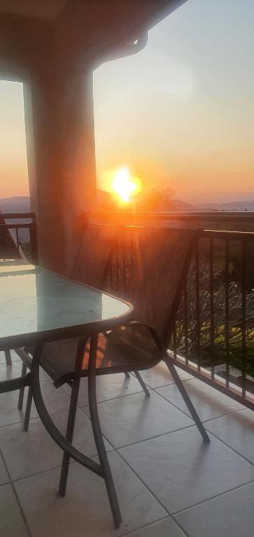 une table sur un balcon avec vue sur le coucher de soleil en arrière-plan dans l'établissement Sun view, à Nelspruit