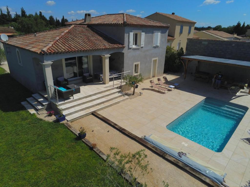 a house with a swimming pool in front of a house at Proche Saint Rémy de Provence in Mollégès