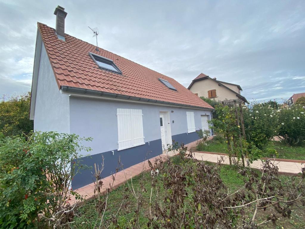 ein weißes und blaues Haus mit rotem Dach in der Unterkunft Un petit coin de bonheurs Maison entière classée 3 étoiles in Oberhergheim