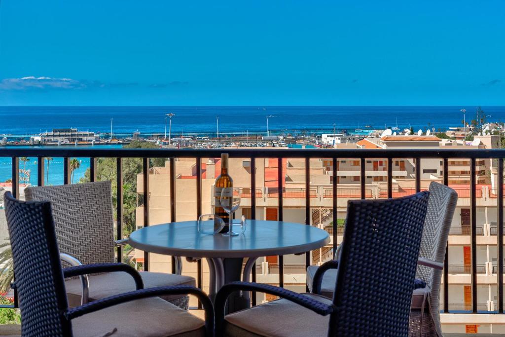 stół i krzesła na balkonie z widokiem na ocean w obiekcie Los Cristianos Achacay Bluesky Apartment w mieście Los Cristianos