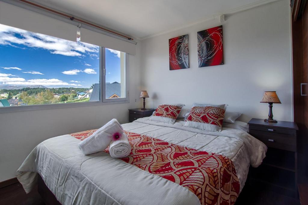 1 dormitorio con cama y ventana grande en Departamento con vista al lago en Bariloche. en San Carlos de Bariloche