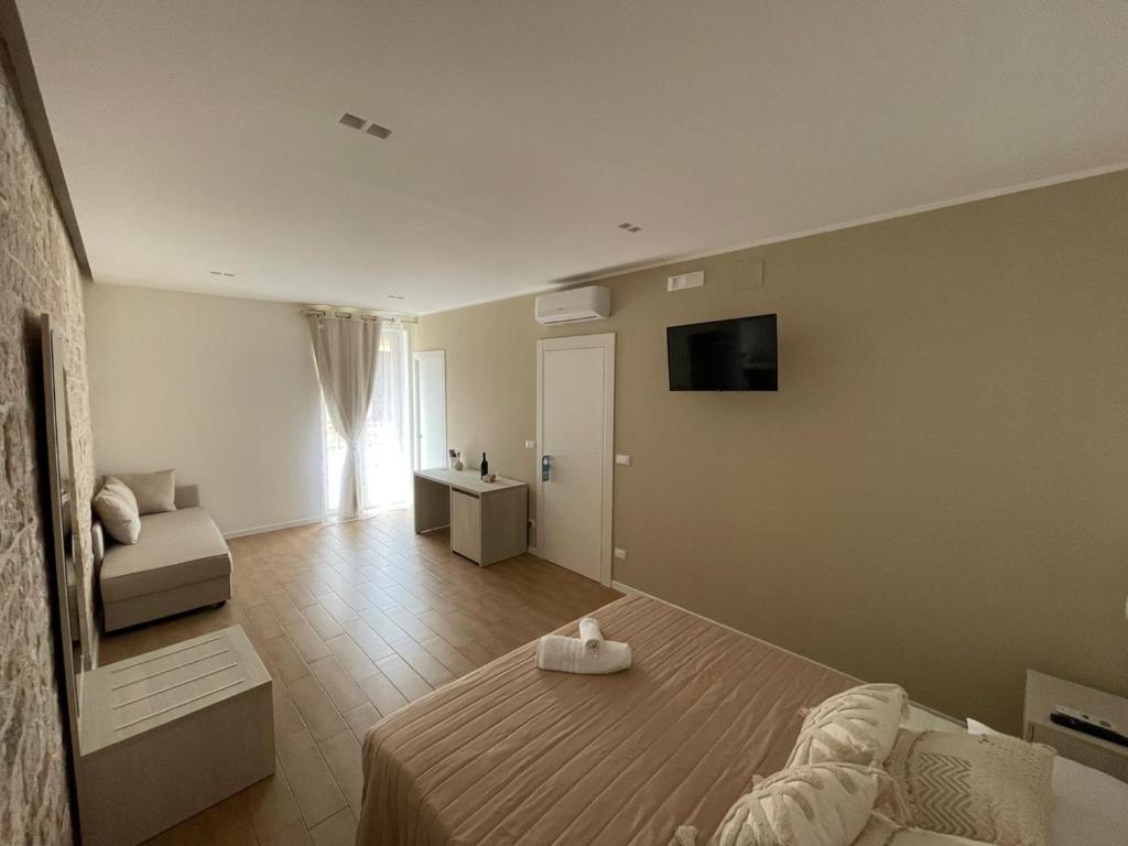 1 dormitorio con 1 cama y TV en la pared en Casa Mariù, en Turi