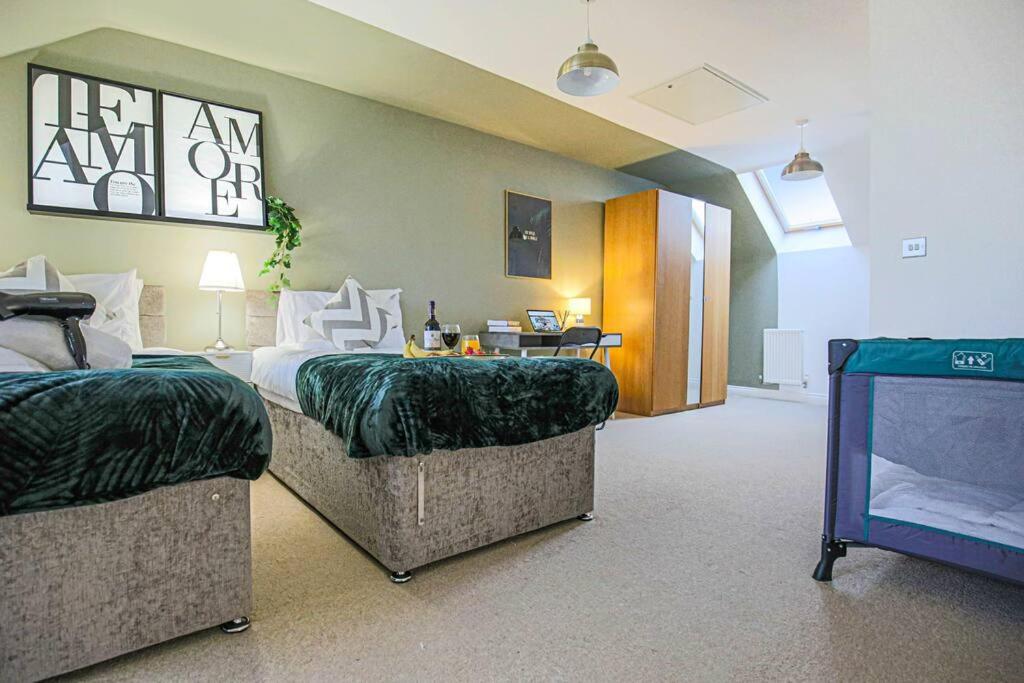 a hotel room with two beds and a desk at Bewdley House - 5 Bedroom 3.5 Bathroom House - Free Parking, Private Garden, Super-Fast Wifi and Smart TVs by Yoko Property in Milton Keynes