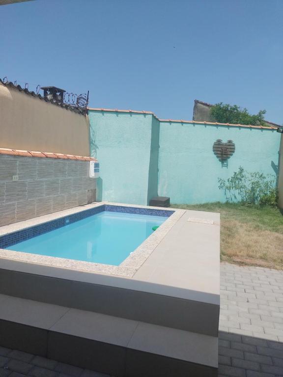 Casa de Praia com piscina في مونغاغوا: مسبح في الحديقة الخلفية للمنزل