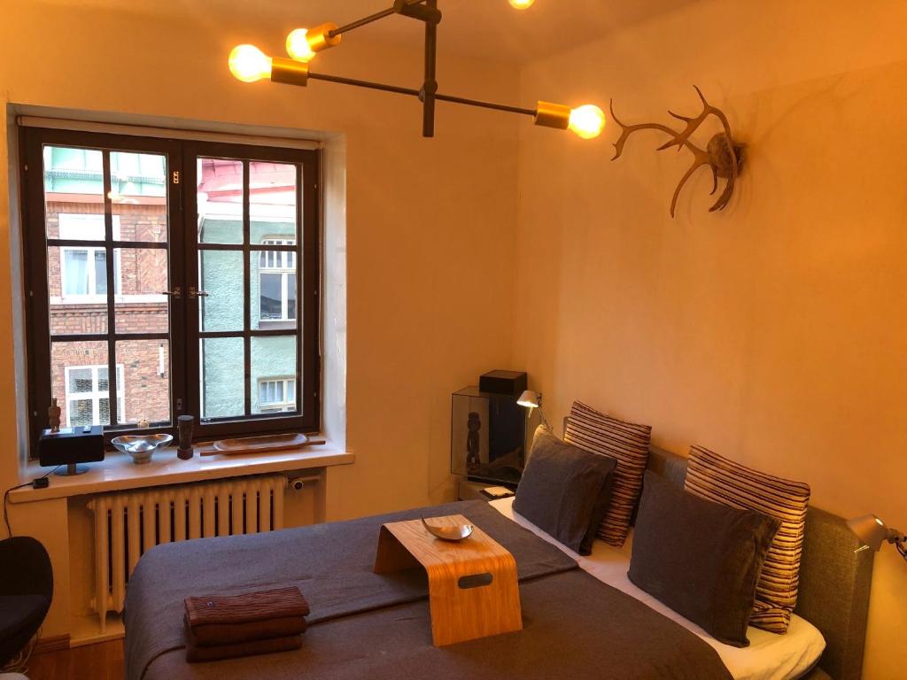 1 dormitorio con cama y ventana en Design District Area - Compact Apartment Helsinki Center, en Helsinki