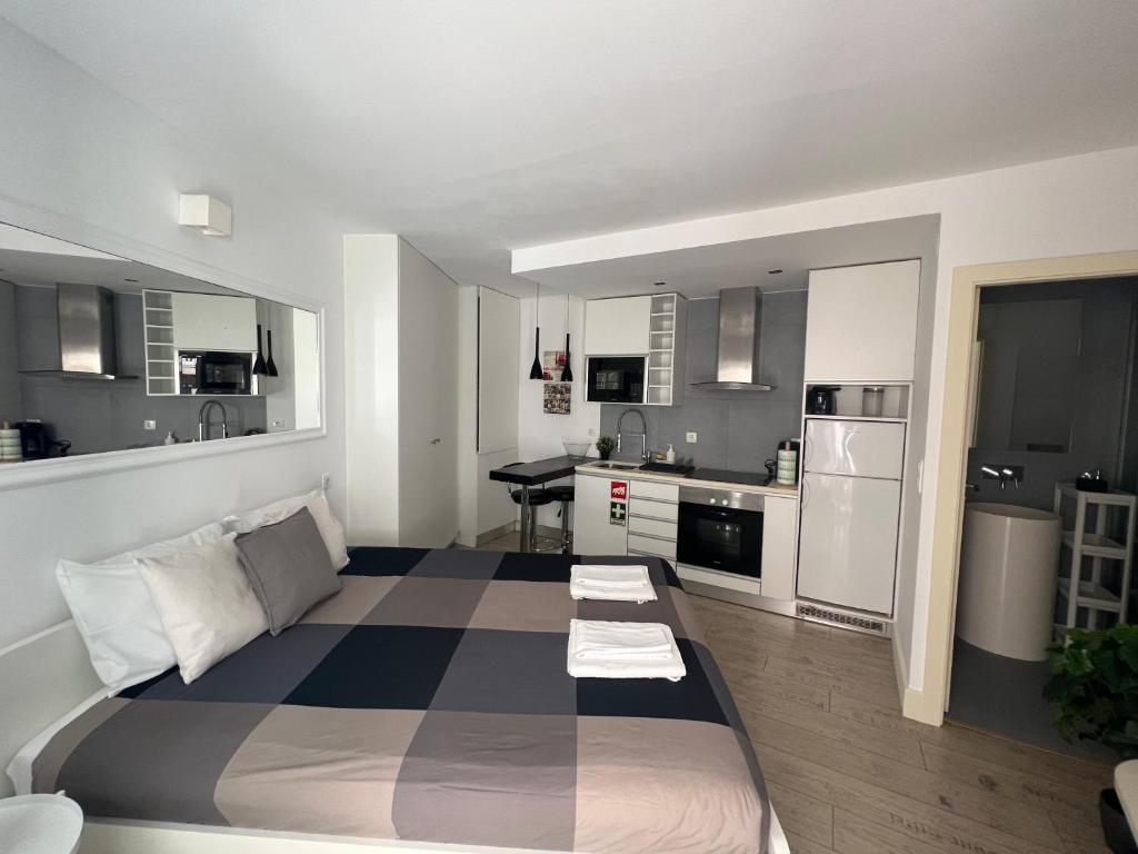 a large bed in a room with a kitchen at Studio in Center of Lisbon in Lisbon