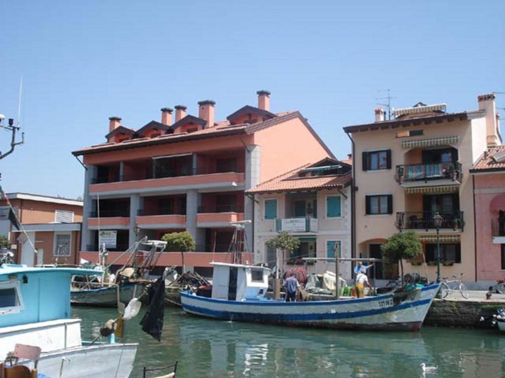 a blue boat in the water next to a building at Stella Marina in Grado