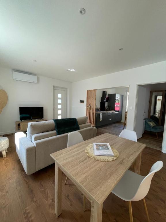 salon ze stołem i kanapą w obiekcie Un logement cosy proche des Ports w mieście Gujan-Mestras
