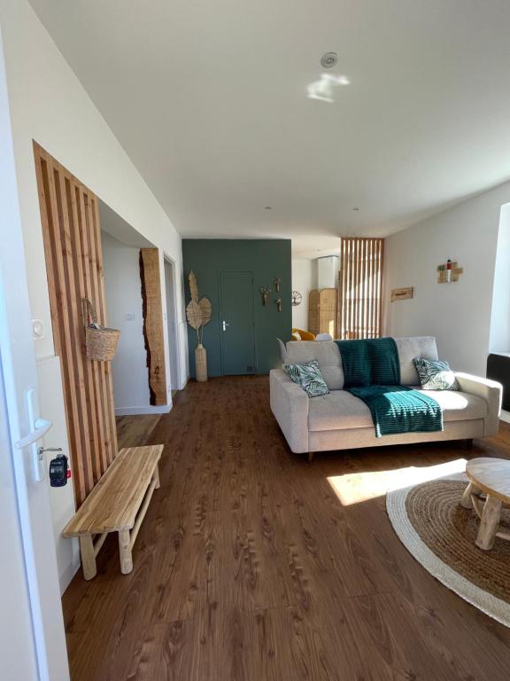 a living room with a couch and a table at Un logement cosy proche des Ports in Gujan-Mestras