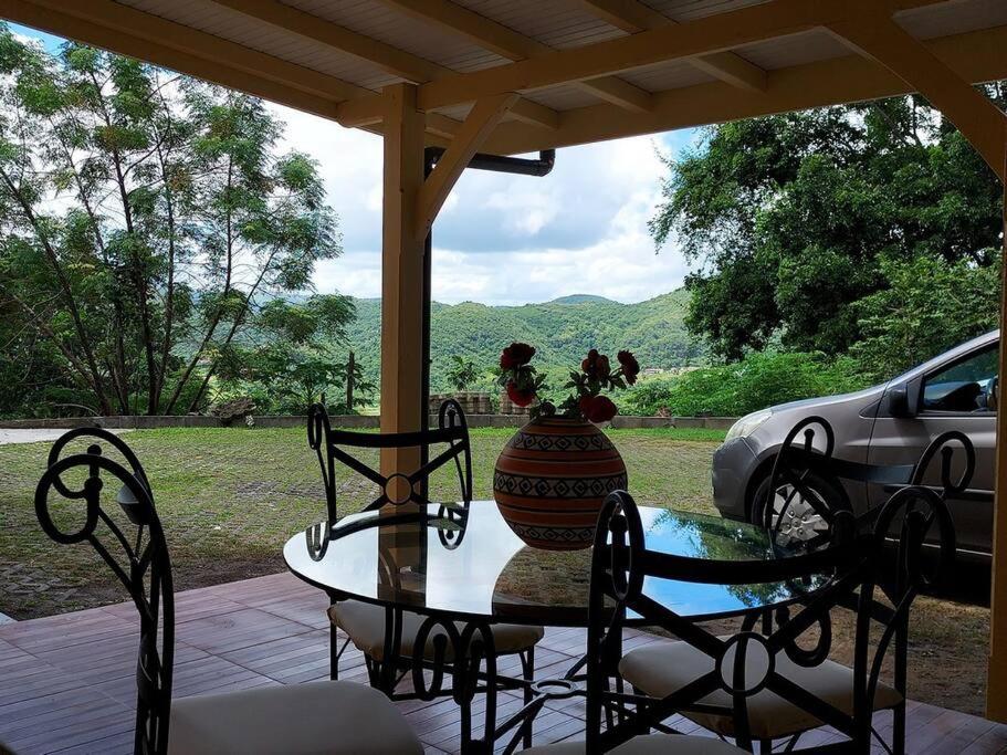 - une table et des chaises sur une terrasse couverte avec un vase dans l'établissement Appartement T2 le Vallon au Marin Martinique, au Marin