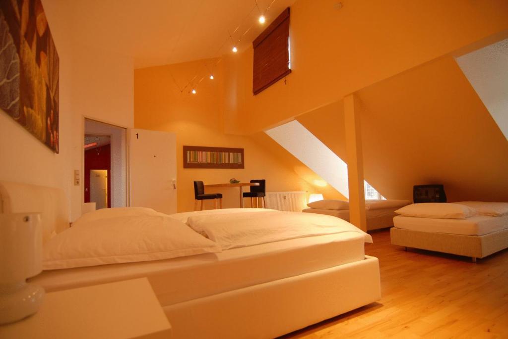 um quarto com uma grande cama branca e um sofá em urraum Hotel former Dreamhouse - rent a room em Pulheim