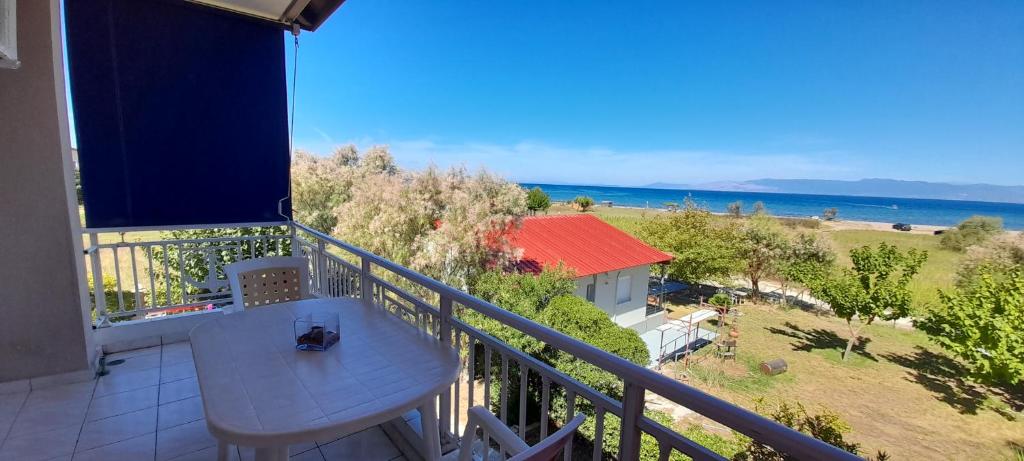 balcón con mesa y vistas al océano en Lakkopetra Beach Apartments, en Lakkópetra