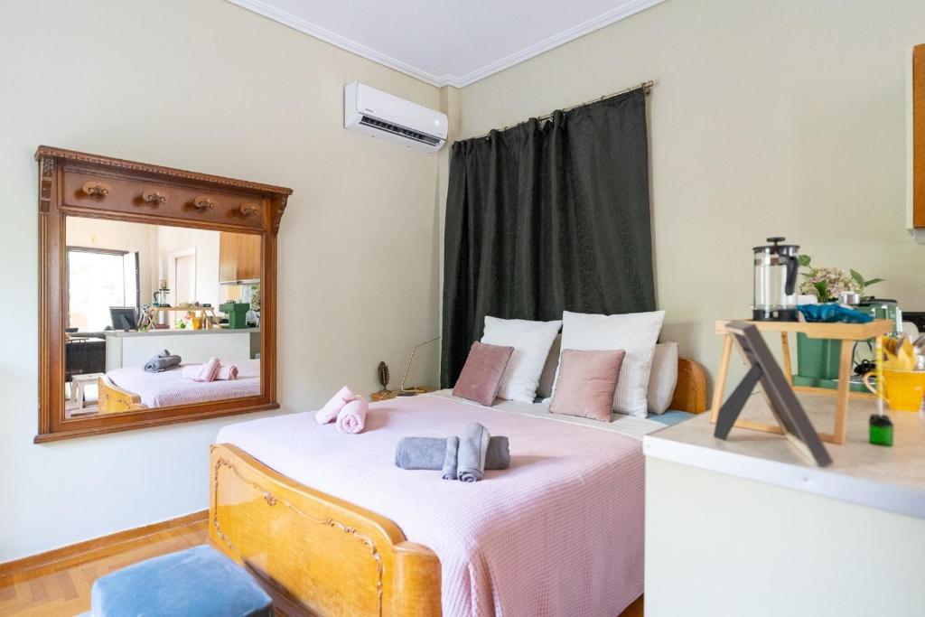 um quarto com uma cama com lençóis cor-de-rosa e um espelho em Magnificent Loft Athens Voula em Atenas