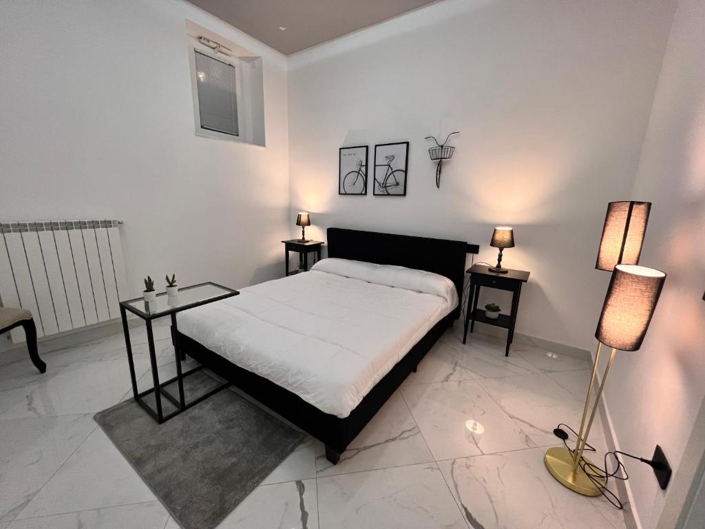 a bedroom with a bed and two tables and two lamps at RaRoom Supernova H in Torre del Greco