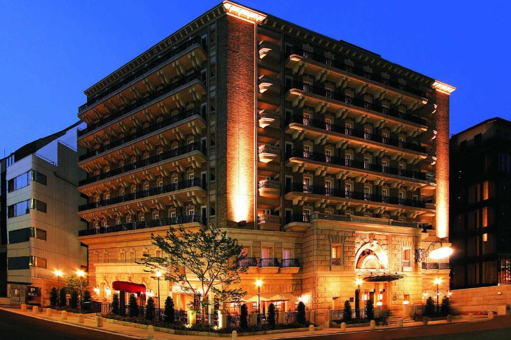 a large building with a tree in front of it at KOKO HOTEL Osaka Shinsaibashi in Osaka