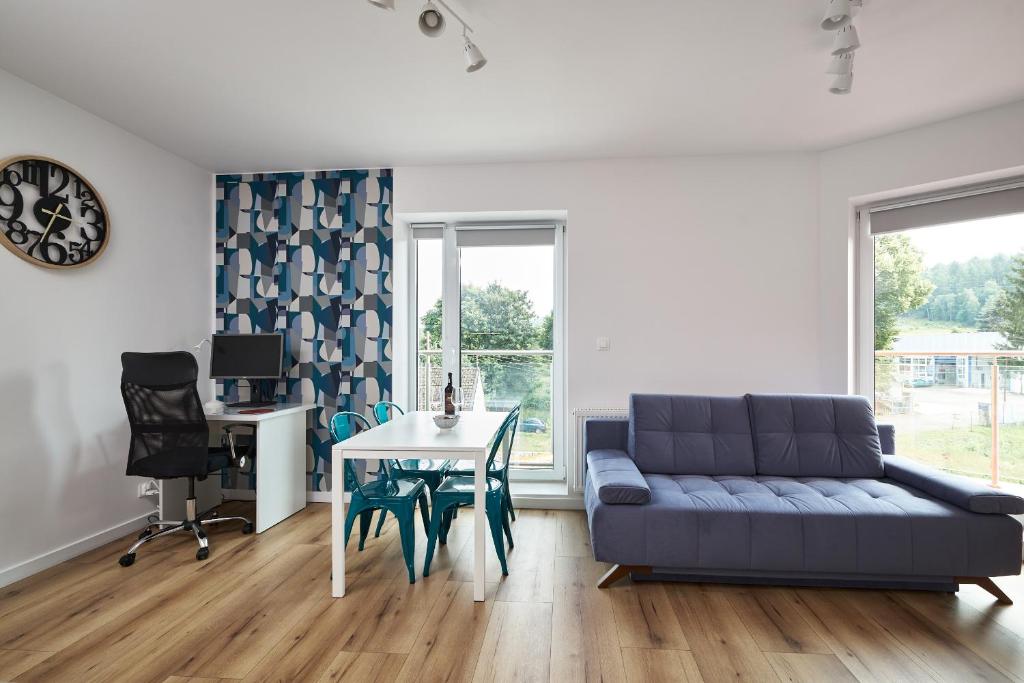 ein Wohnzimmer mit einem Sofa und einem Tisch in der Unterkunft Blue Apartament & Office Kudowa-Zdrój in Kudowa-Zdrój