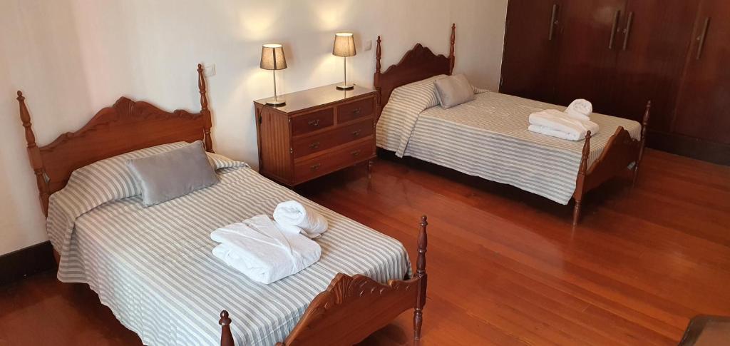 Habitación con 2 camas individuales y suelo de madera. en Casa Andrea, en Las Palmas de Gran Canaria