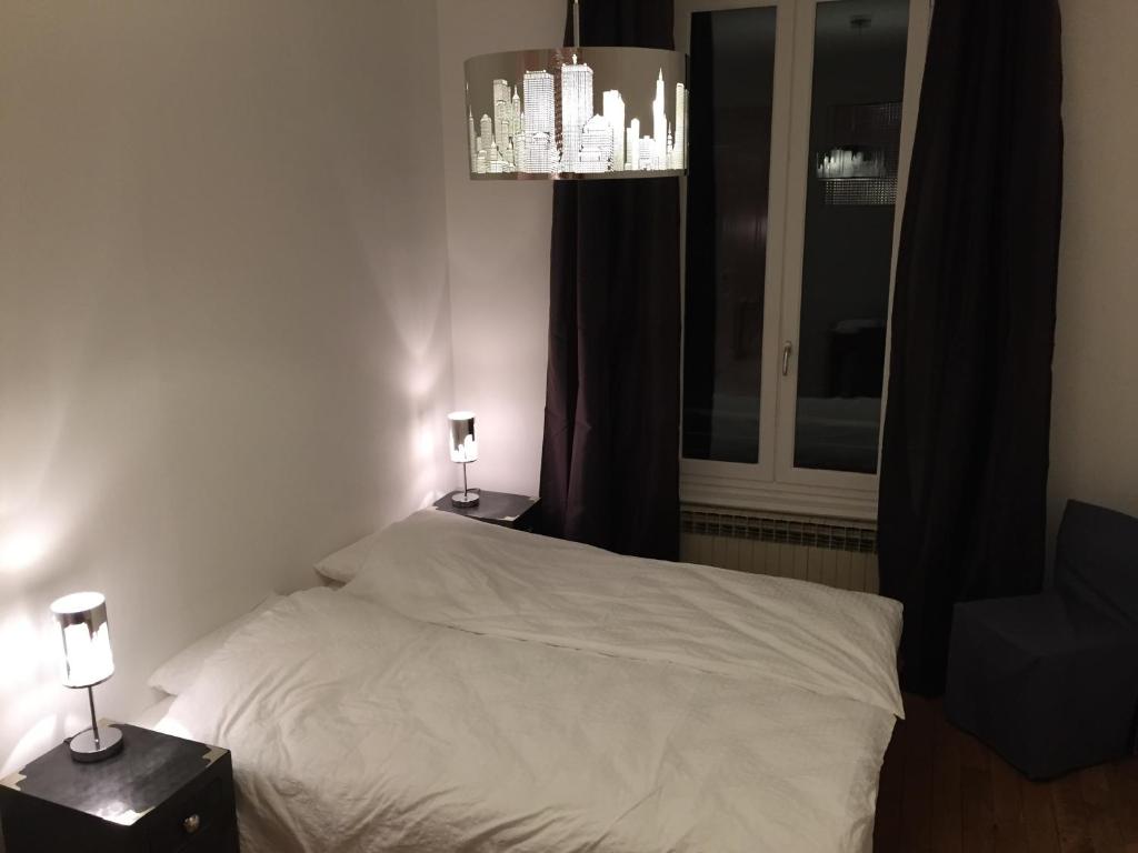 ヴィルールバンヌにあるAppartement, Lyon, Villeurbanneのベッドルーム1室(ベッド1台付)、2泊分のスタンド(ランプ付)
