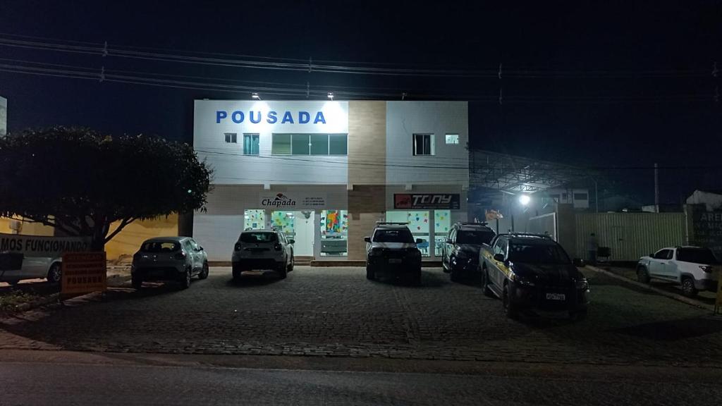 a pucada store with cars parked outside at night at Pousada Chapada do Araripe in Araripina