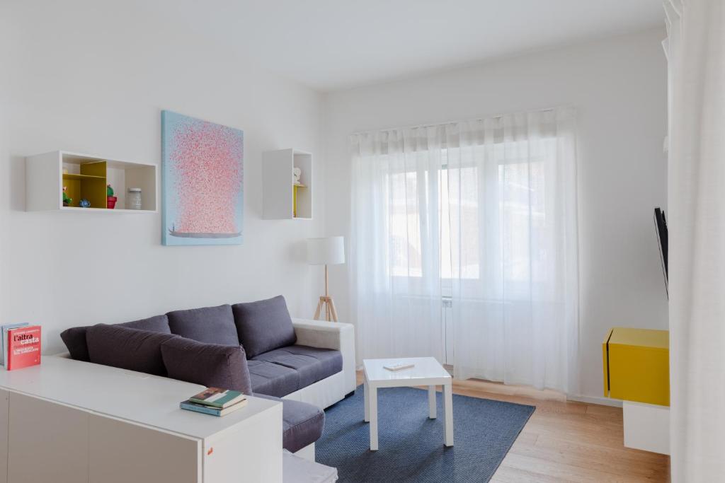 salon z kanapą i stołem w obiekcie Stupendo appartamento in quartiere residenziale w Rzymie