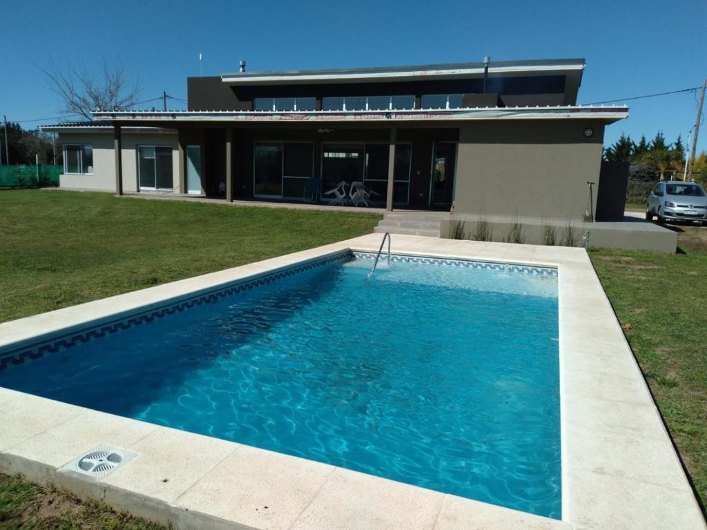 una piscina frente a una casa en PALAZZOLO CASA DE CAMPO Y RELAX en San Pedro