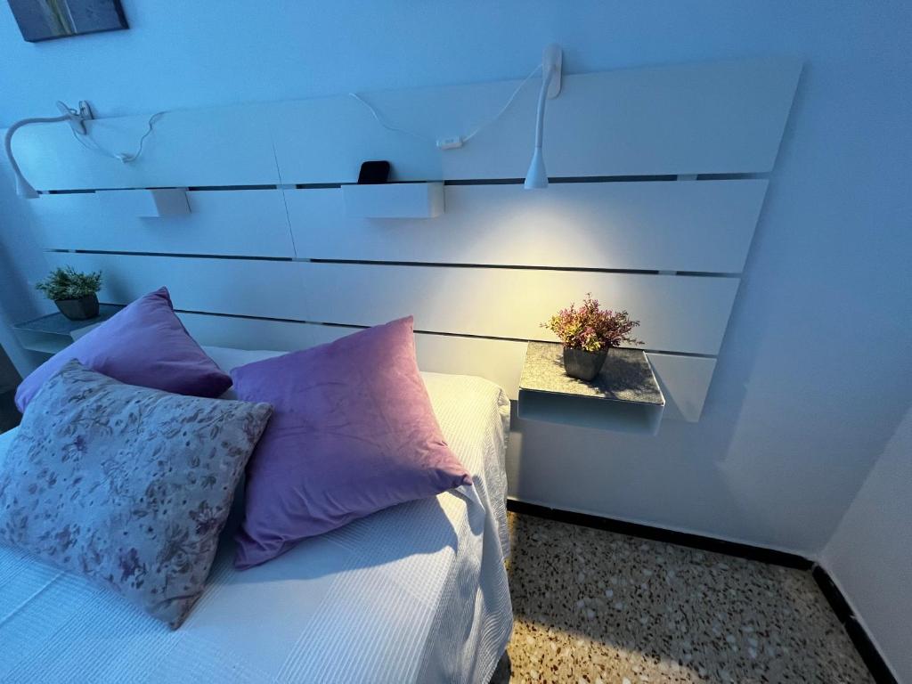 a bedroom with a bed with purple pillows at Sarah Kite II Vv, Room 2 in Playa del Burrero