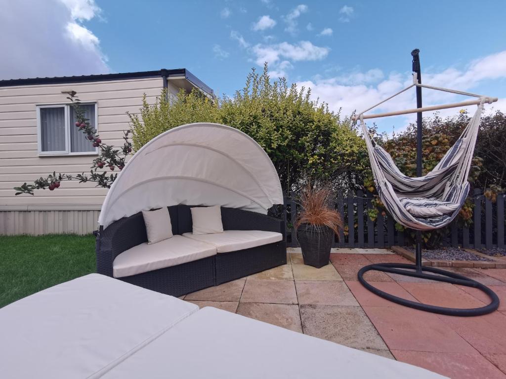 a hammock and a couch in a yard at Lakes and woodlands Overstone Holiday Park in Northampton