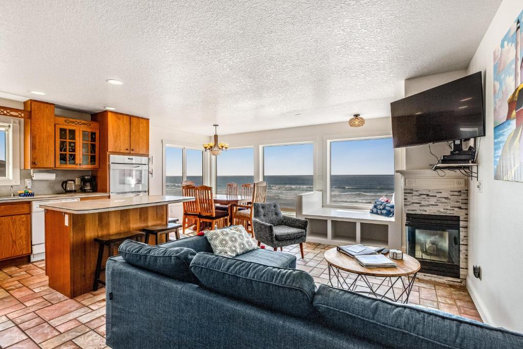 a living room with a couch and a kitchen with a fireplace at Sand Castle 1 in Rockaway Beach