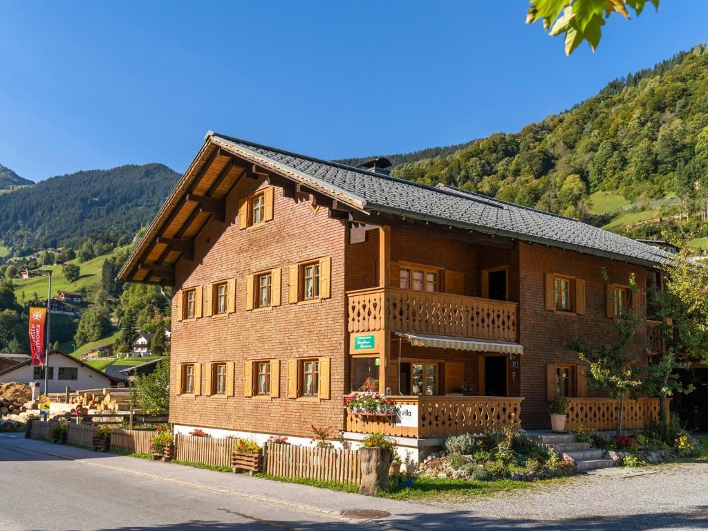 a large brick building with a balcony on a mountain at Landhaus Barbara in Silbertal
