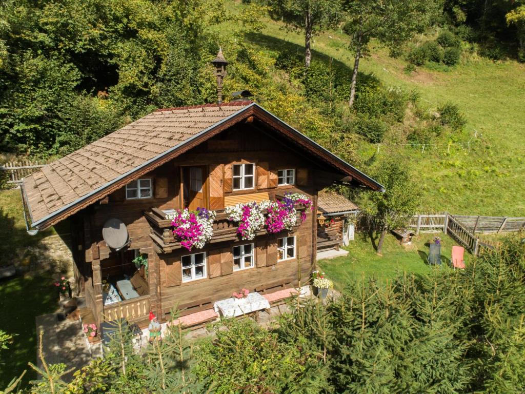 une petite maison en bois avec des fleurs sur le toit dans l'établissement Sonnrasthütte, à Untergaimberg