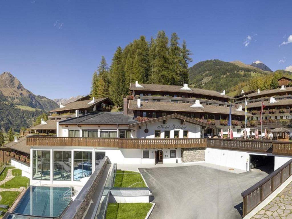 ein Haus mit Pool und Bergen im Hintergrund in der Unterkunft Matrei Park 55 in Matrei in Osttirol