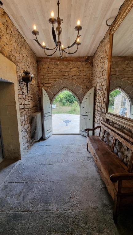 un pasillo con puertas y un banco en una habitación en Le Manoir de Menglieu, en Treffléan