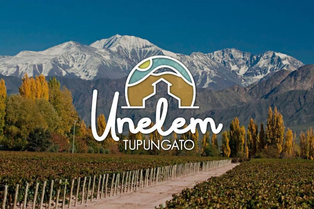 a sign for a vineyard with mountains in the background at Unelem Tupungato in Tupungato