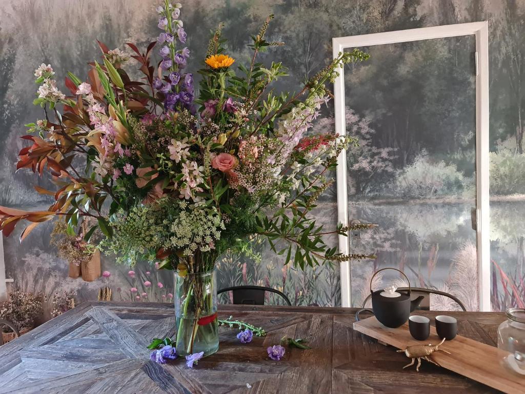 een vaas gevuld met bloemen zittend op een tafel bij mi casa de buenos aires in Buenos Aires