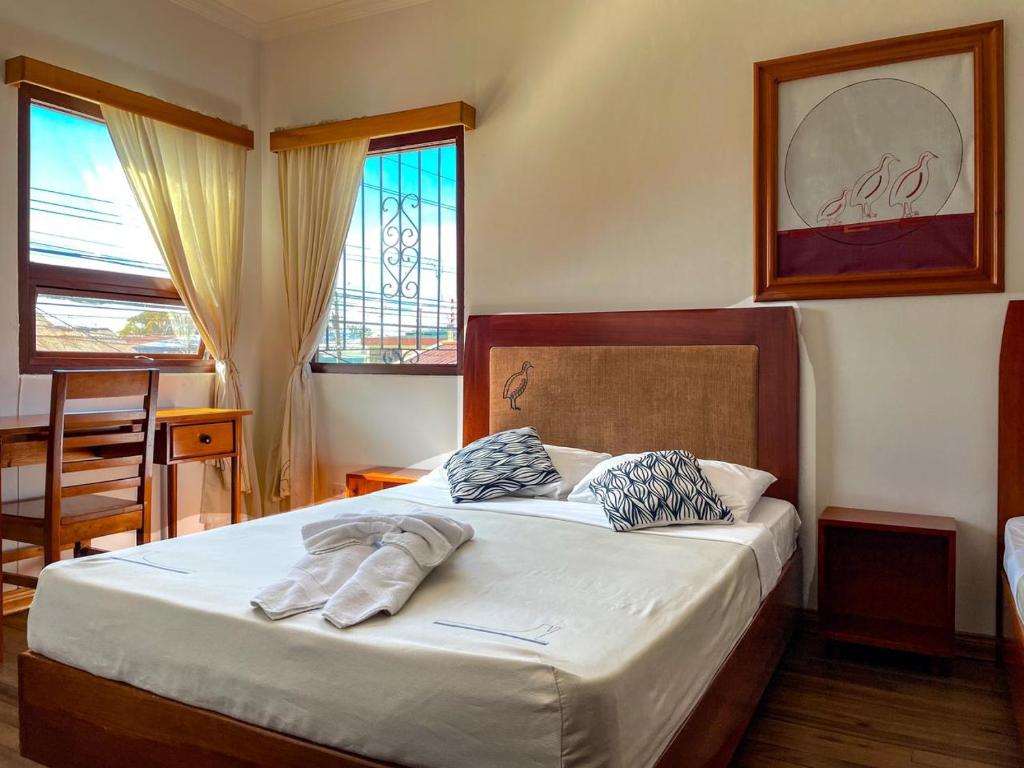 a bedroom with a bed with two pillows on it at Hotel Luz de Luna in San José