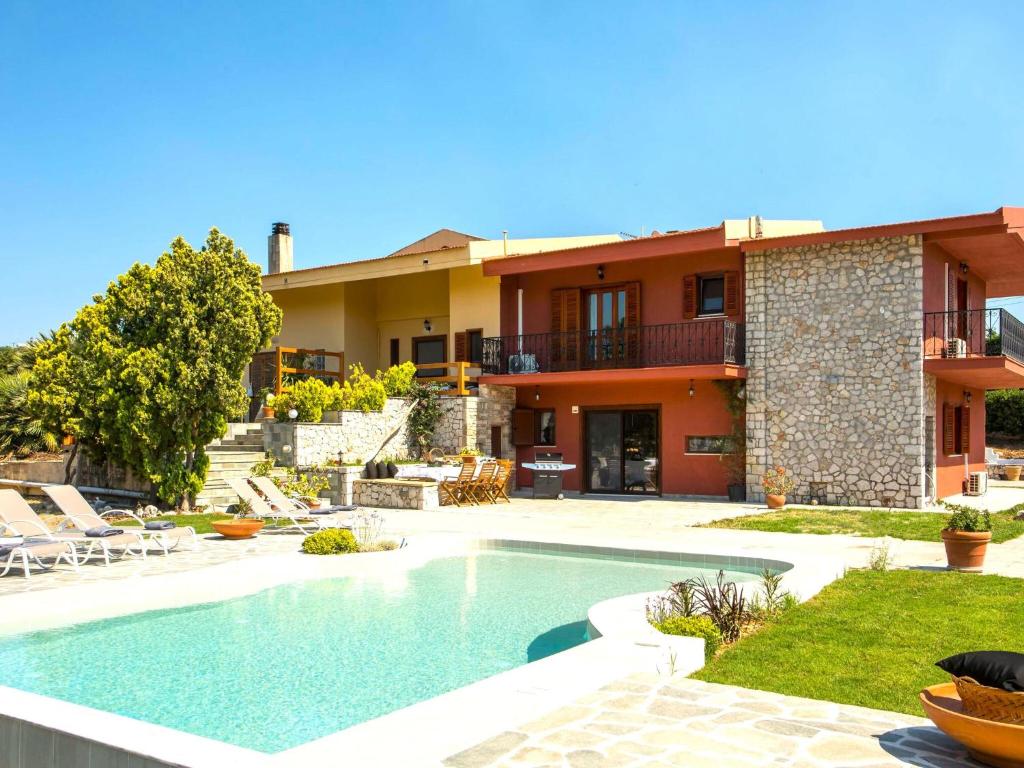 une villa avec piscine devant une maison dans l'établissement Holiday Home near Beach in Afandou, à Koskinou
