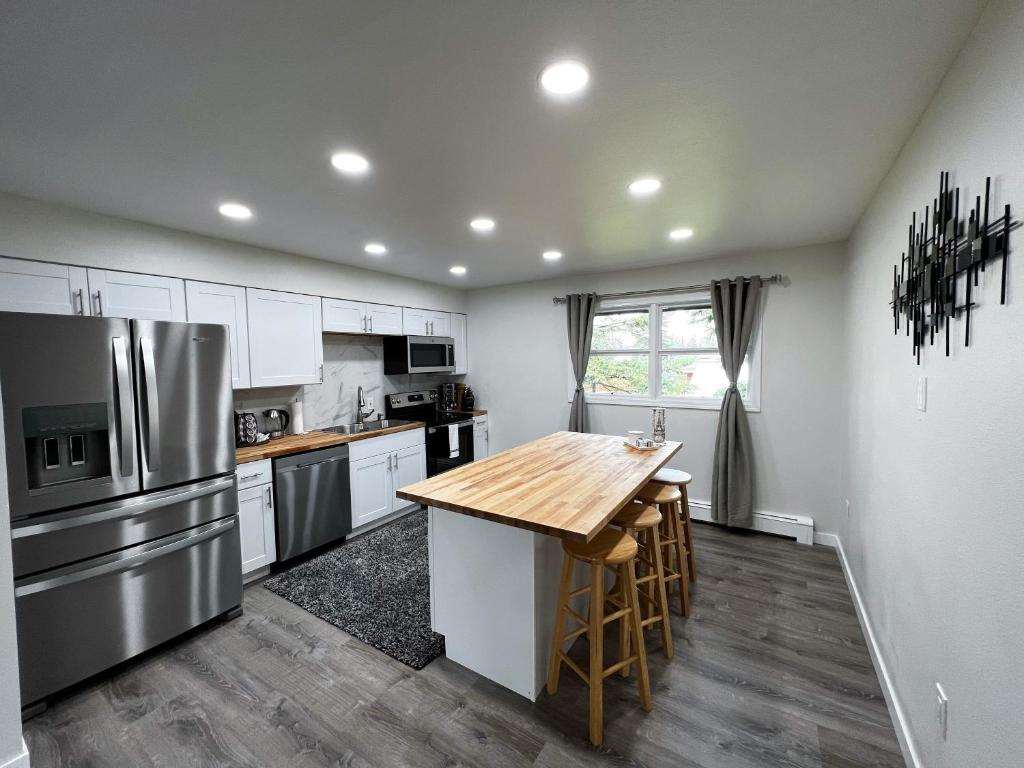 cocina con armarios blancos y mesa de madera en Anchorage midtown apartment-Wyoming 2 en Anchorage