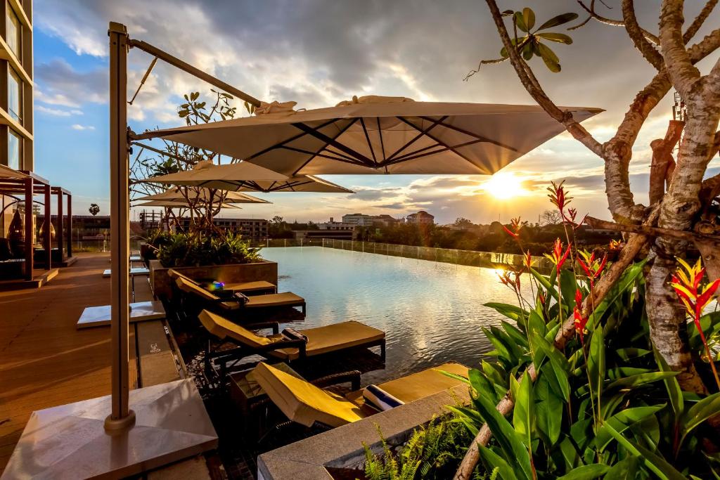 a pool with an umbrella and a table and chairs at Crowne Plaza Vientiane, an IHG Hotel in Vientiane