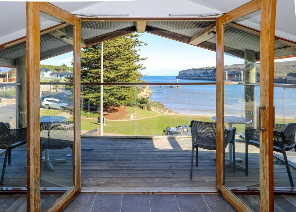 a screened in porch with a view of the ocean at 12 Rocks Beach View Loft Central Port Campbell in Port Campbell