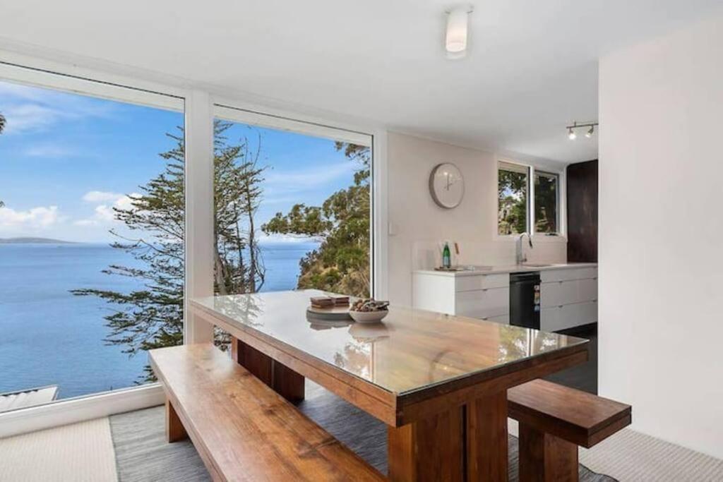 Hidden Bay Retreat-5 Bed- 15min to Hobart في هوبارت: مطبخ مع طاولة وإطلالة على المحيط